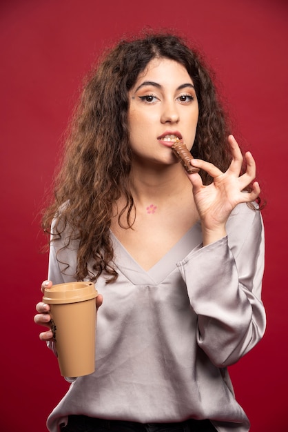 Mujer rizada comiendo chocolate.