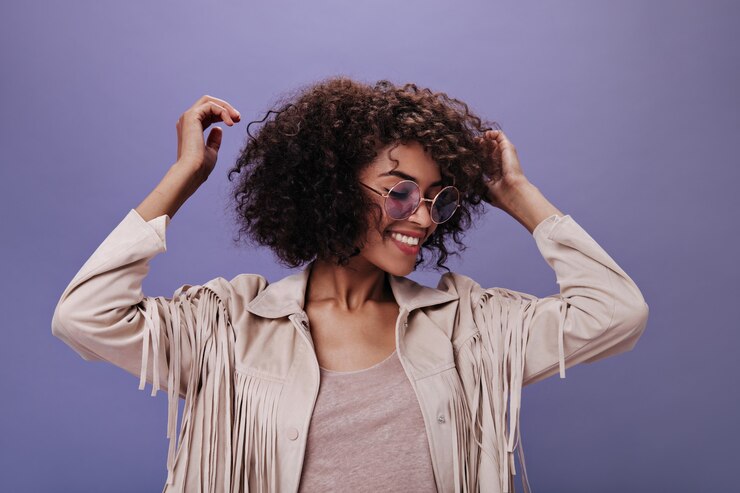 Foto gratuito mujer rizada de muy buen humor bailando en la pared púrpura