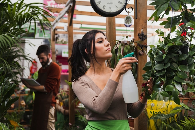 Foto gratuita mujer rociando plantas