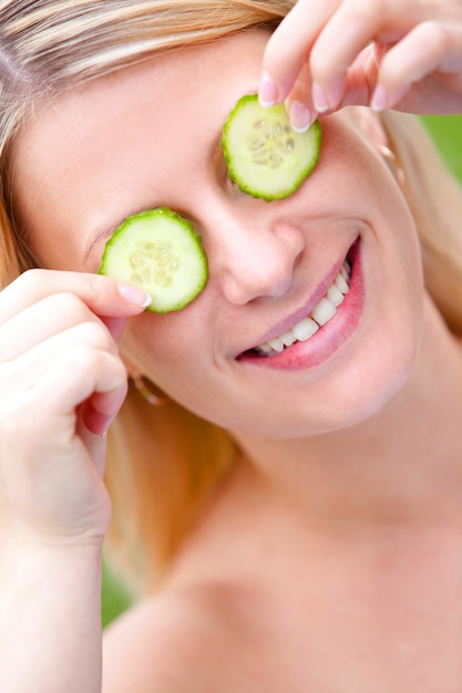 Mujer con rodajas de pepino sobre su rostro