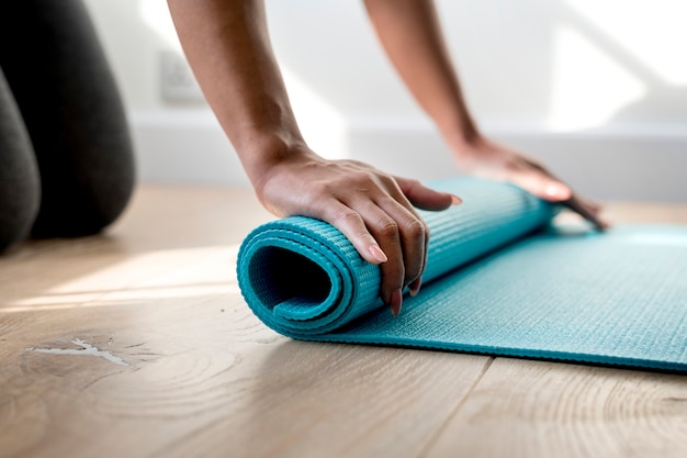 Mujer rodando tapete de yoga