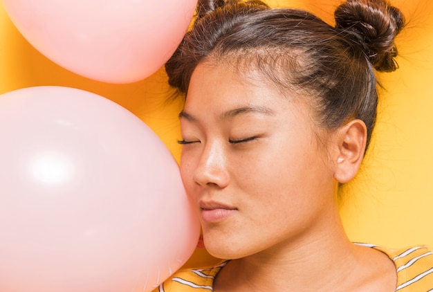 Mujer rodeada de globos rosas