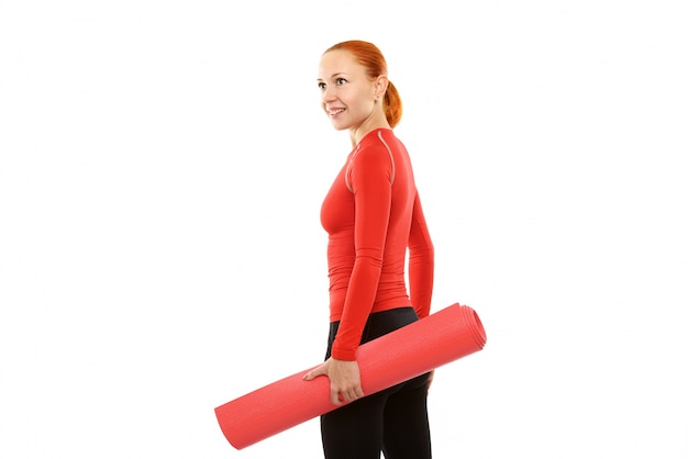 Mujer roja con estera de yoga