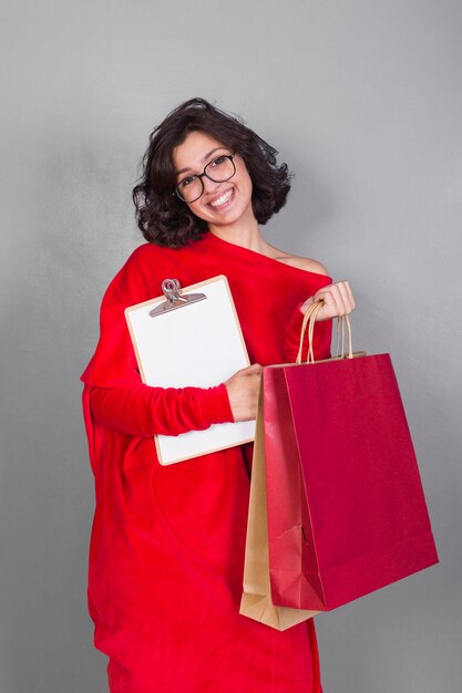 Mujer en rojo con bolsas de la compra.