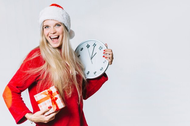 Mujer en rojo con reloj y caja de regalo.