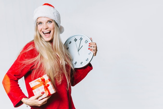 Mujer en rojo con reloj y caja de regalo.