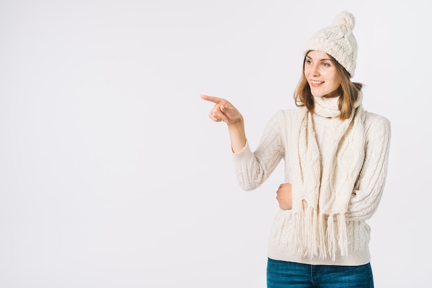 Foto gratuita mujer en ropa de abrigo apuntando a un lado