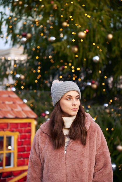 Mujer en ropa de abrigo en el mercado de Navidad