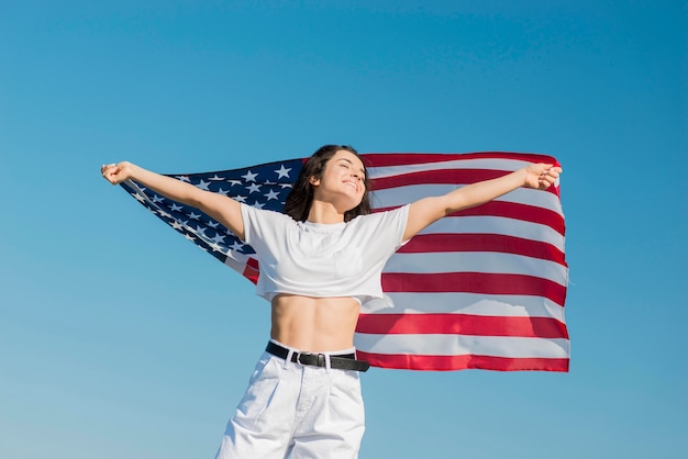 Foto gratuita mujer en ropa blanca con gran bandera de estados unidos