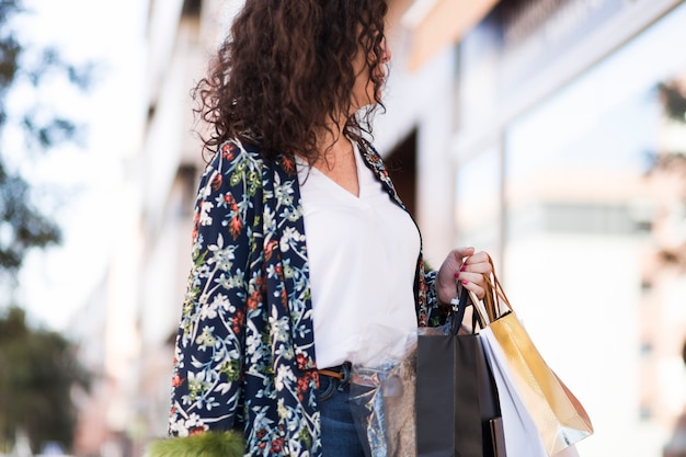 Foto gratuita mujer en ropa casual de pie con bolsas de compras