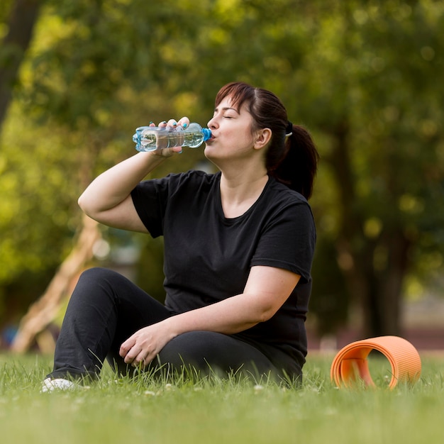 Foto gratuita mujer en ropa deportiva agua potable