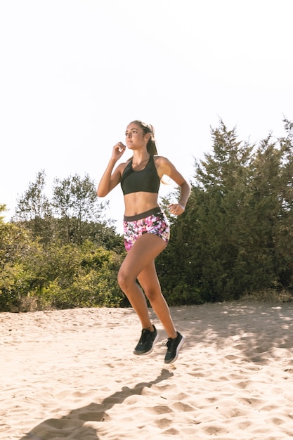 Mujer en ropa deportiva para correr en la arena