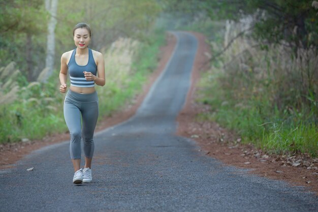 mujer en ropa deportiva corriendo en un parque