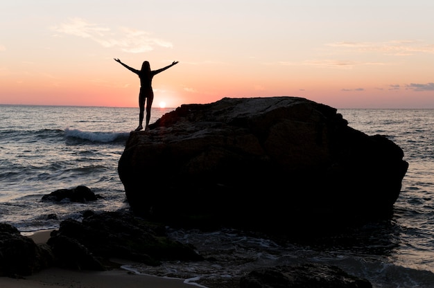 Mujer en ropa deportiva disfrutando de la puesta de sol con espacio de copia