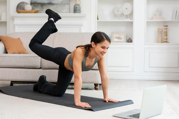 Mujer en ropa deportiva haciendo ejercicio en casa