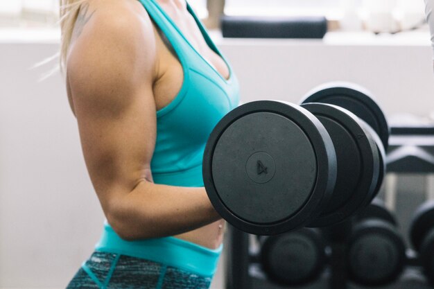 Mujer en ropa deportiva levantando pesas