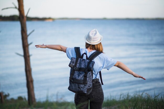 Mujer sin rostro caminando hacia el lago