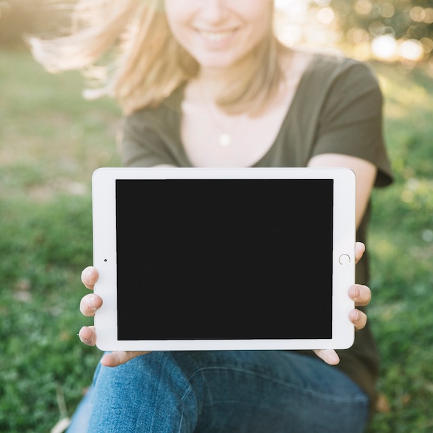 Foto gratuita mujer sin rostro mostrando tableta