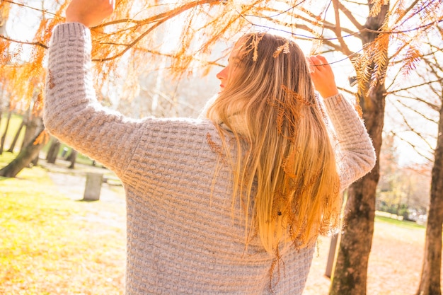 Mujer sin rostro en el parque de otoño