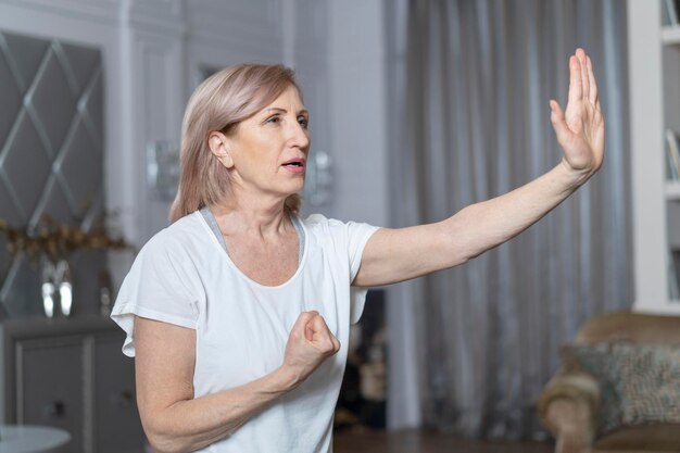 Mujer rubia de 50 o 60 años de edad que practica yoga Ha estado practicando yoga durante muchos años Generalmente practica en casa Primer plano