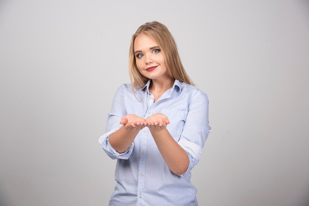 Mujer rubia abrió sus manos para dar algo