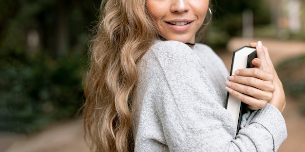 Foto gratuita mujer rubia agujereando cerca de un libro