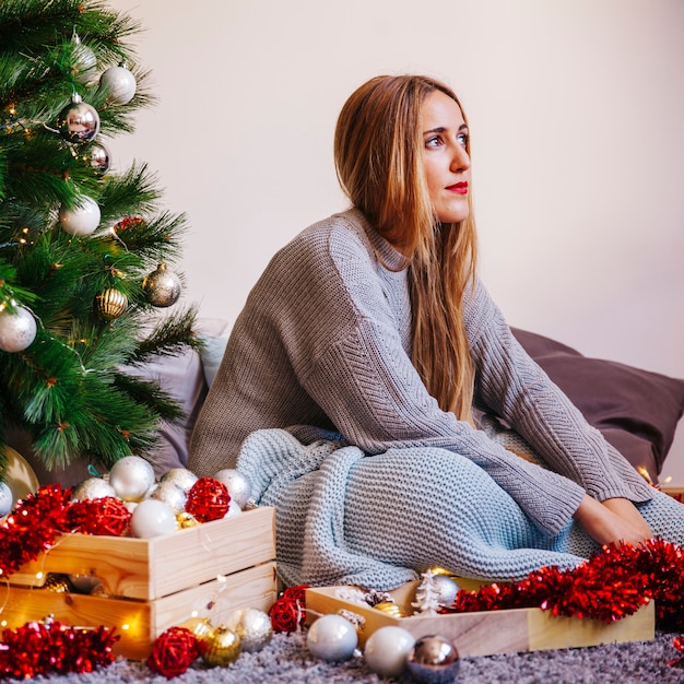 Foto gratuita mujer rubia al lado de su árbol de navidad