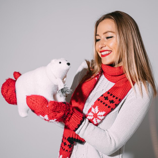 Mujer rubia alegre posando con oso polar de juguete