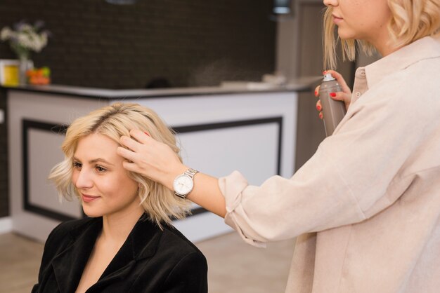 Mujer rubia arreglándose el pelo