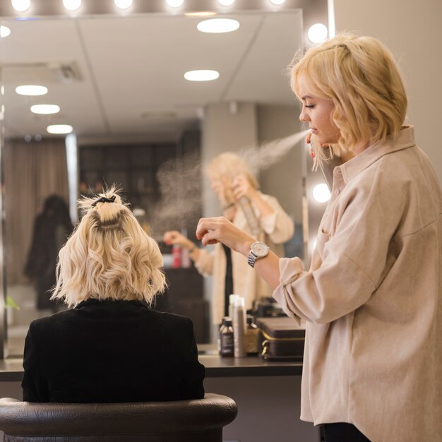 Mujer rubia arreglándose el pelo