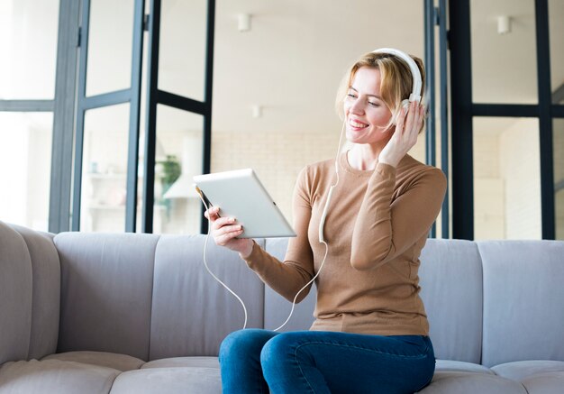 Mujer rubia en auriculares escuchando música