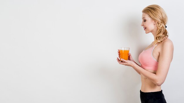 Mujer rubia bebiendo zumo de naranja
