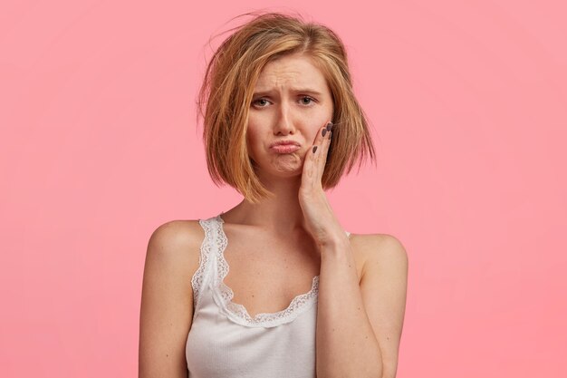 Mujer rubia con cabello desordenado vistiendo top