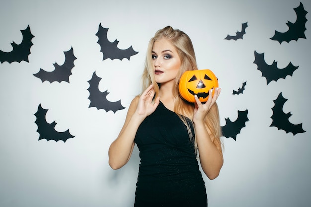 Mujer rubia con calabaza de Halloween