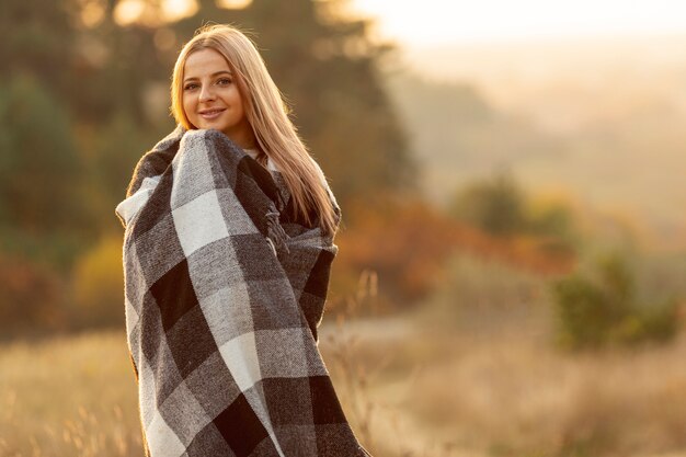 Mujer rubia calentándose con una gran bufanda