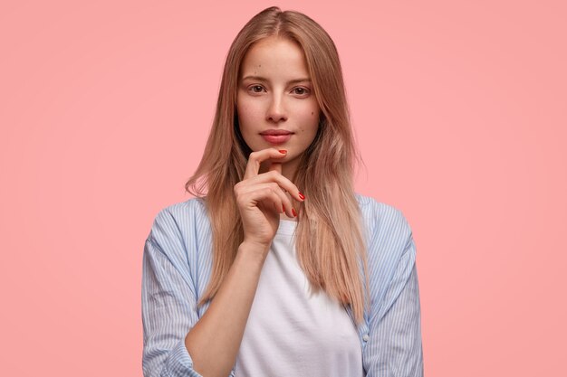 Mujer rubia en camisa a rayas posando