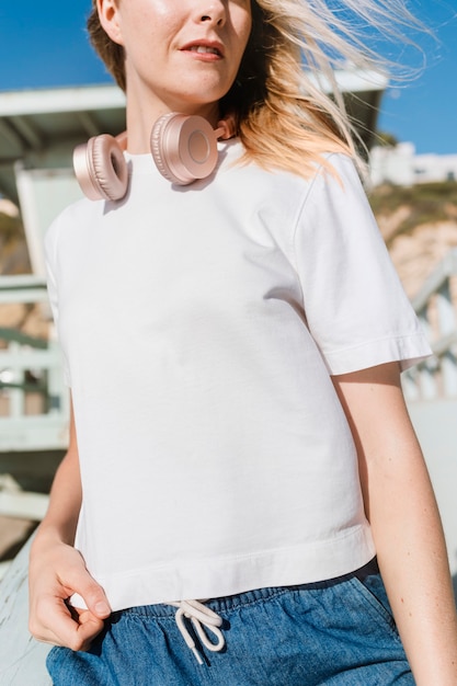 Mujer rubia en camiseta blanca en la playa