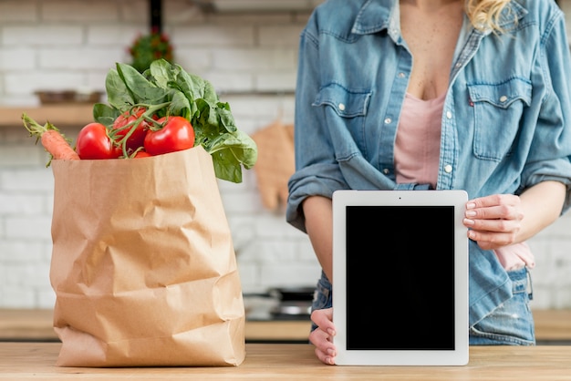 Mujer rubia en la cocina con una tablet