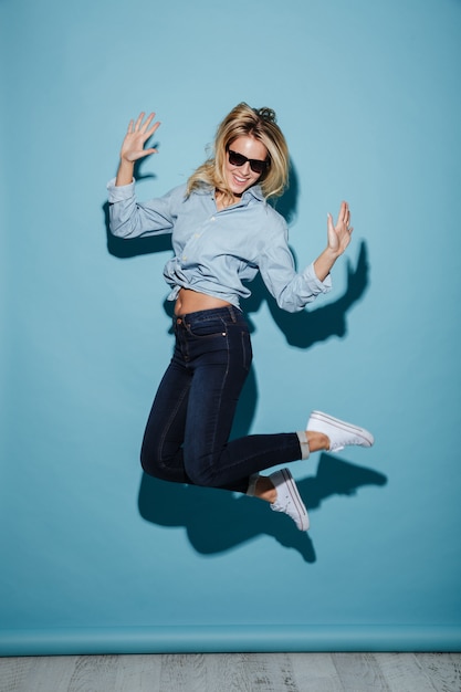 Mujer rubia complacida en camisa y gafas de sol