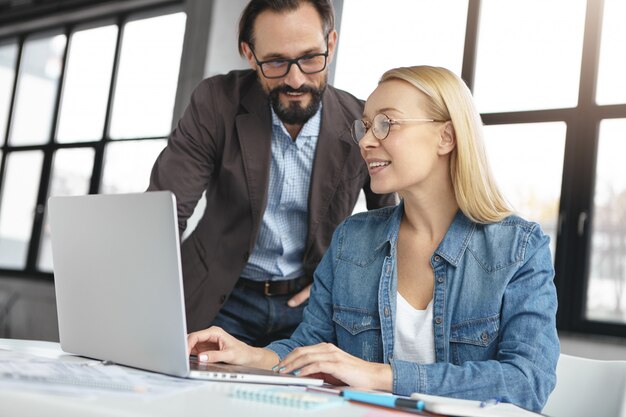 Mujer rubia conversando con un colega de trabajo