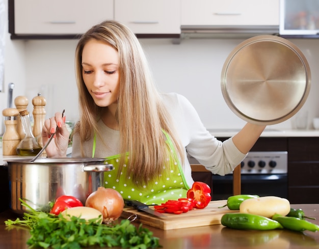 Foto gratuita mujer rubia con cucharón prueba sopa de pan