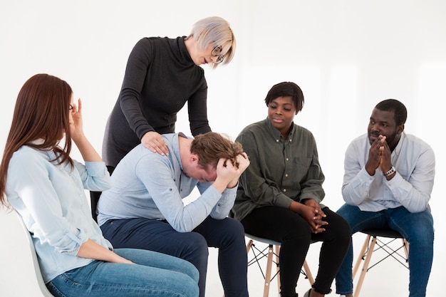 Foto gratuita mujer rubia cuidando paciente de rehabilitación masculina