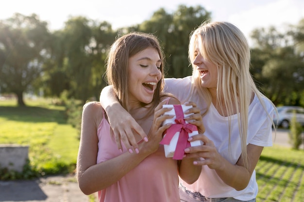 Mujer rubia dando un regalo a su amiga