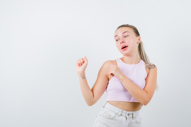 Mujer rubia está bailando sobre fondo blanco.