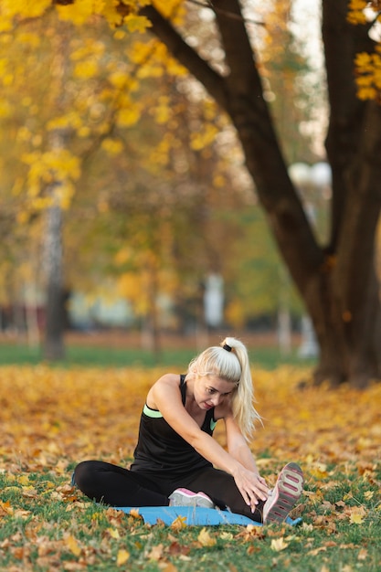 Mujer rubia estirando afuera