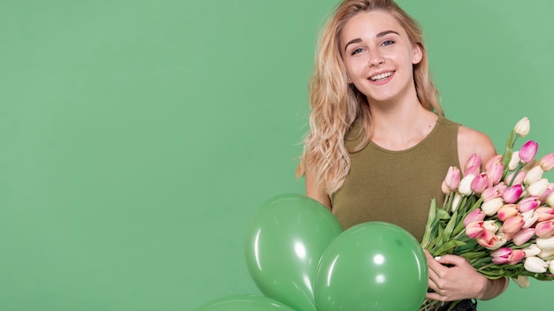 Mujer rubia con flores y globos