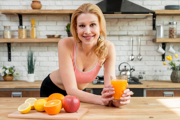 Mujer rubia con frutas en la cocina