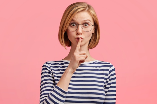 Mujer rubia con gafas redondas y blusa a rayas