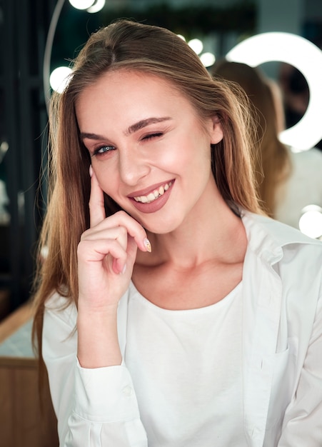 Foto gratuita mujer rubia guiñando un ojo y sonriendo