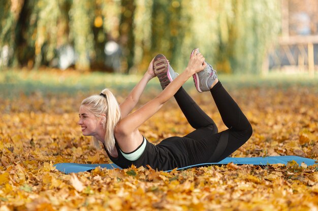 Mujer rubia haciendo fitness en la naturaleza